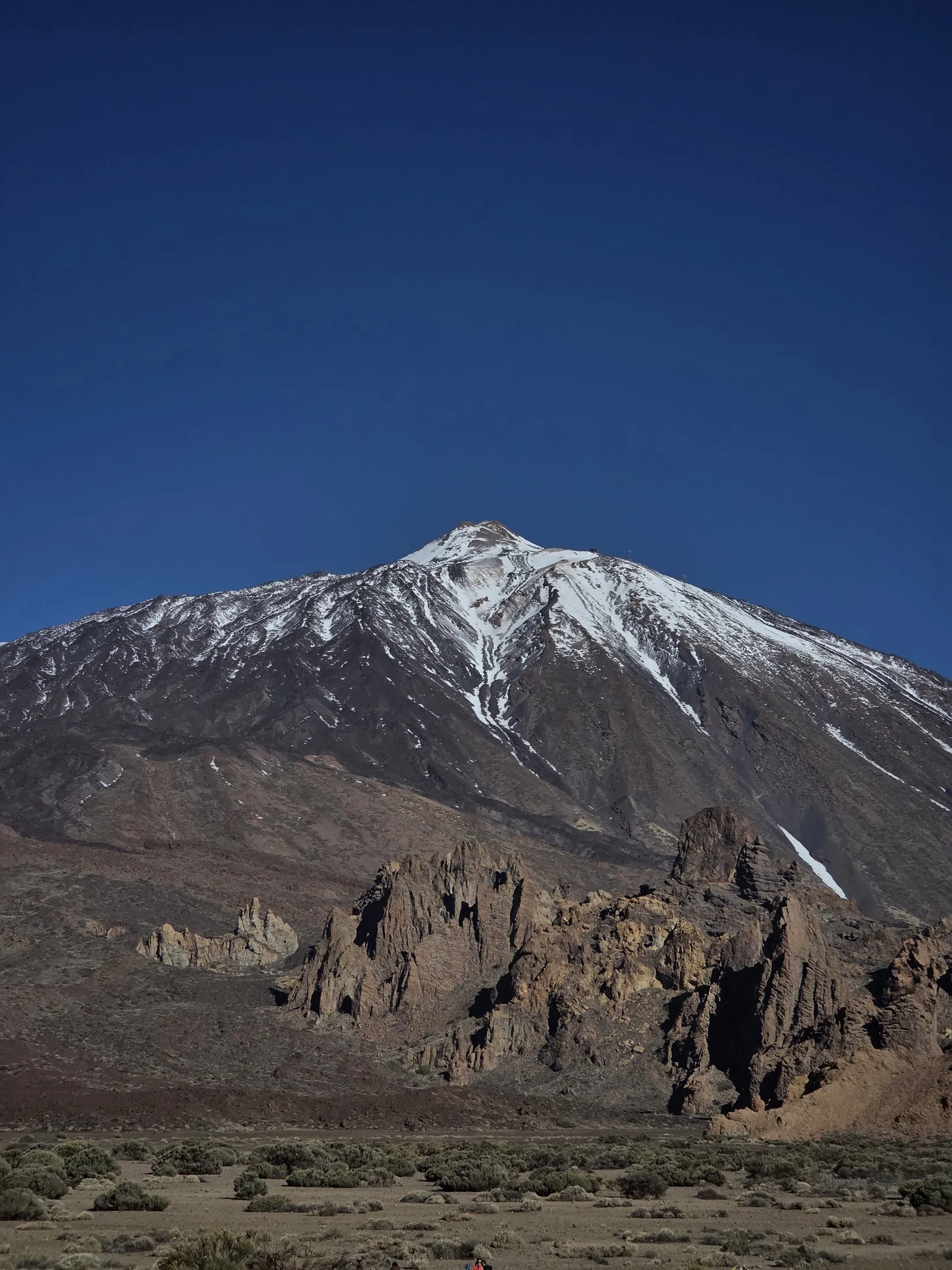 The snow-capped cone of Teide from the lava field