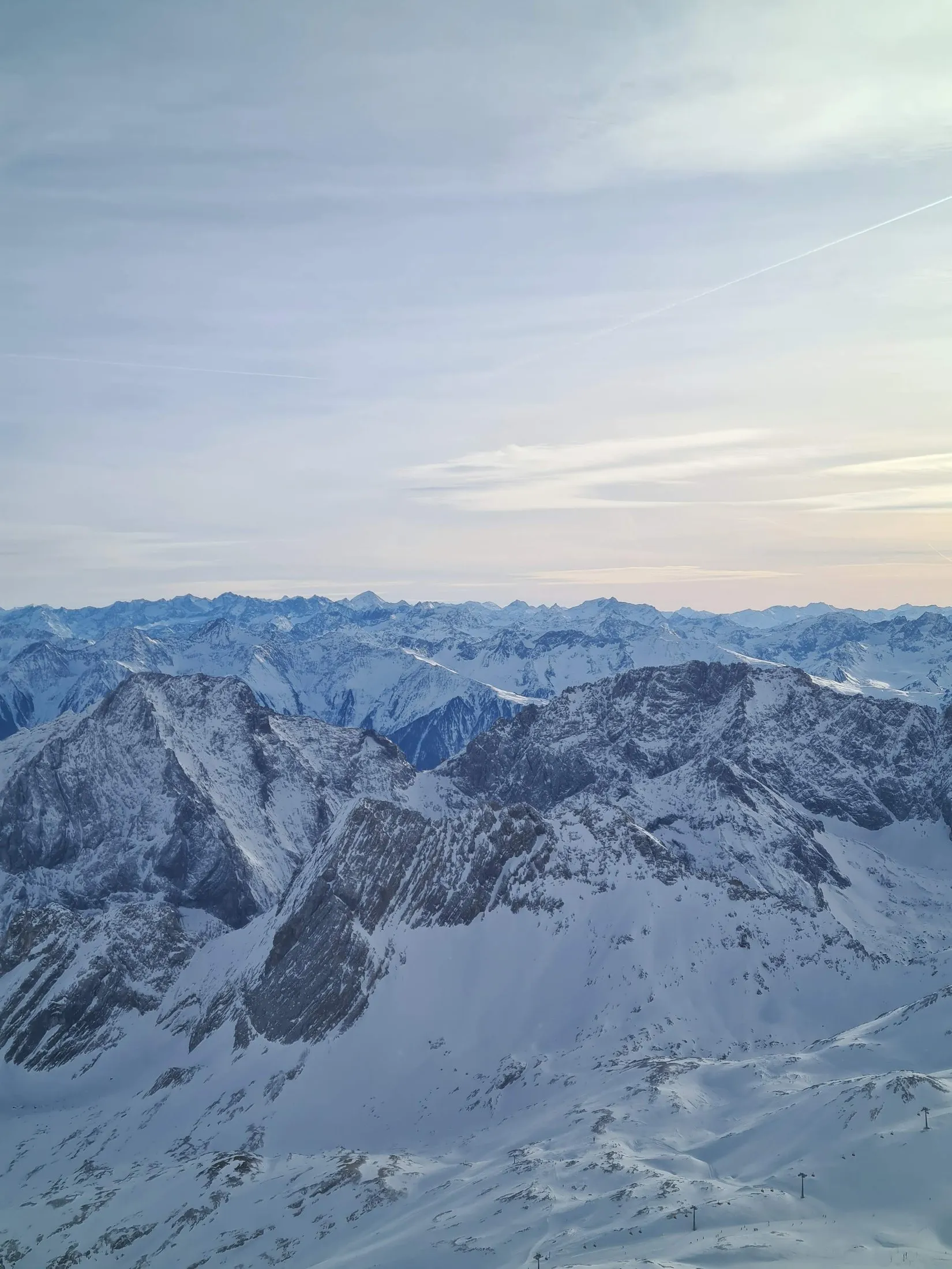 A high snow range under a pale winter sky