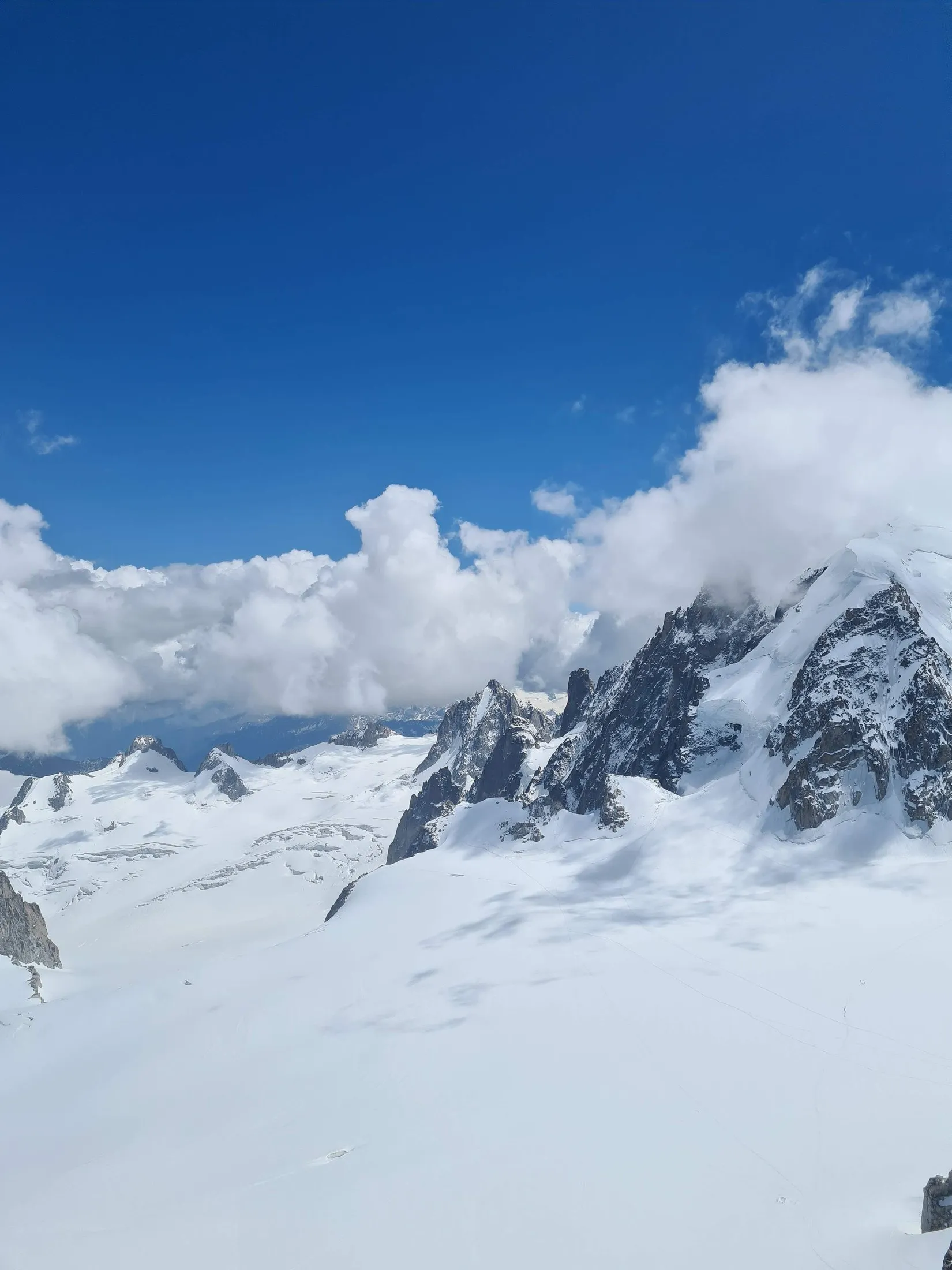 Cloud breaking over a snow-covered alpine ridge