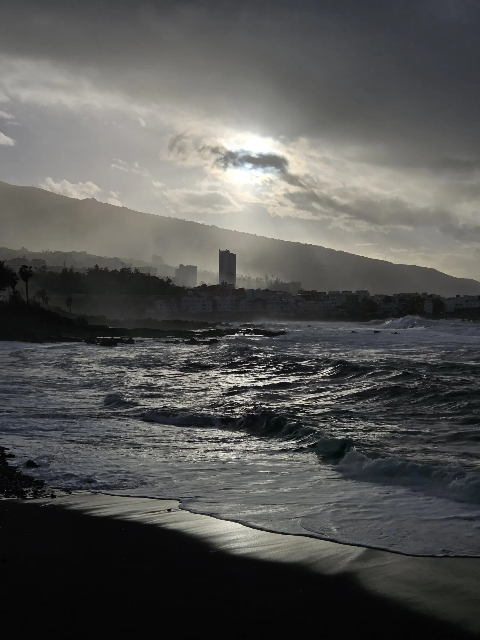 Rough waves under a dark sky along the town shore